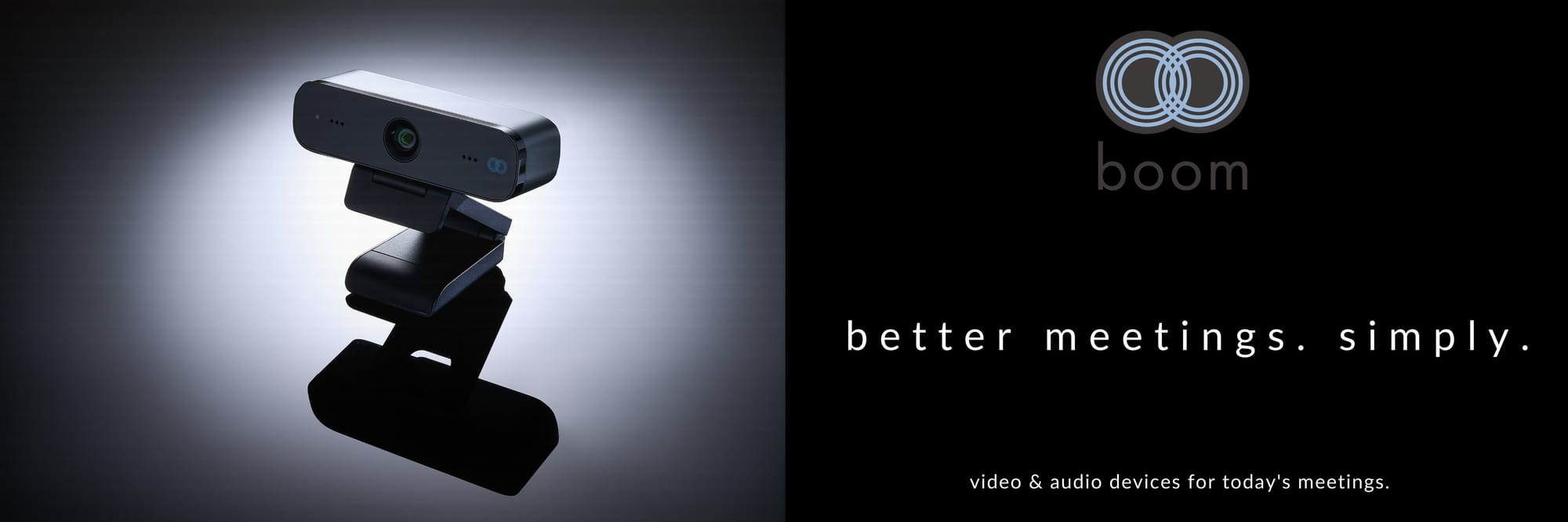 The image features a banner with a dark background that gradually lightens toward the center. On the left side, a webcam is positioned, mounted on a stand. On the right side, a logo with two interlocking circles appears above the word 'boom.' Below the logo, the text reads 'better meetings. simply.' At the very bottom, the text reads 'video & audio devices for today's meetings.'